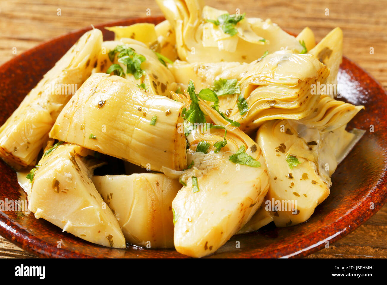 Artichoke hearts dressed in oil and herb marinade Stock Photo Alamy
