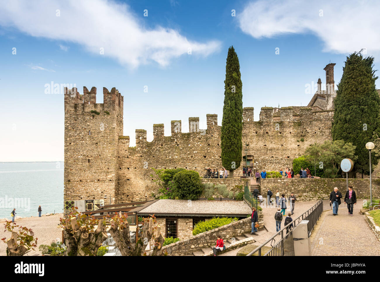 SIRMIONE, ITALY - APRIL 23: Tourists at Scaliger Castle in Sirmione, Italy on April 23, 2014. The castle was built in the 13th century. Foto taken from via Romagnionli. Stock Photo