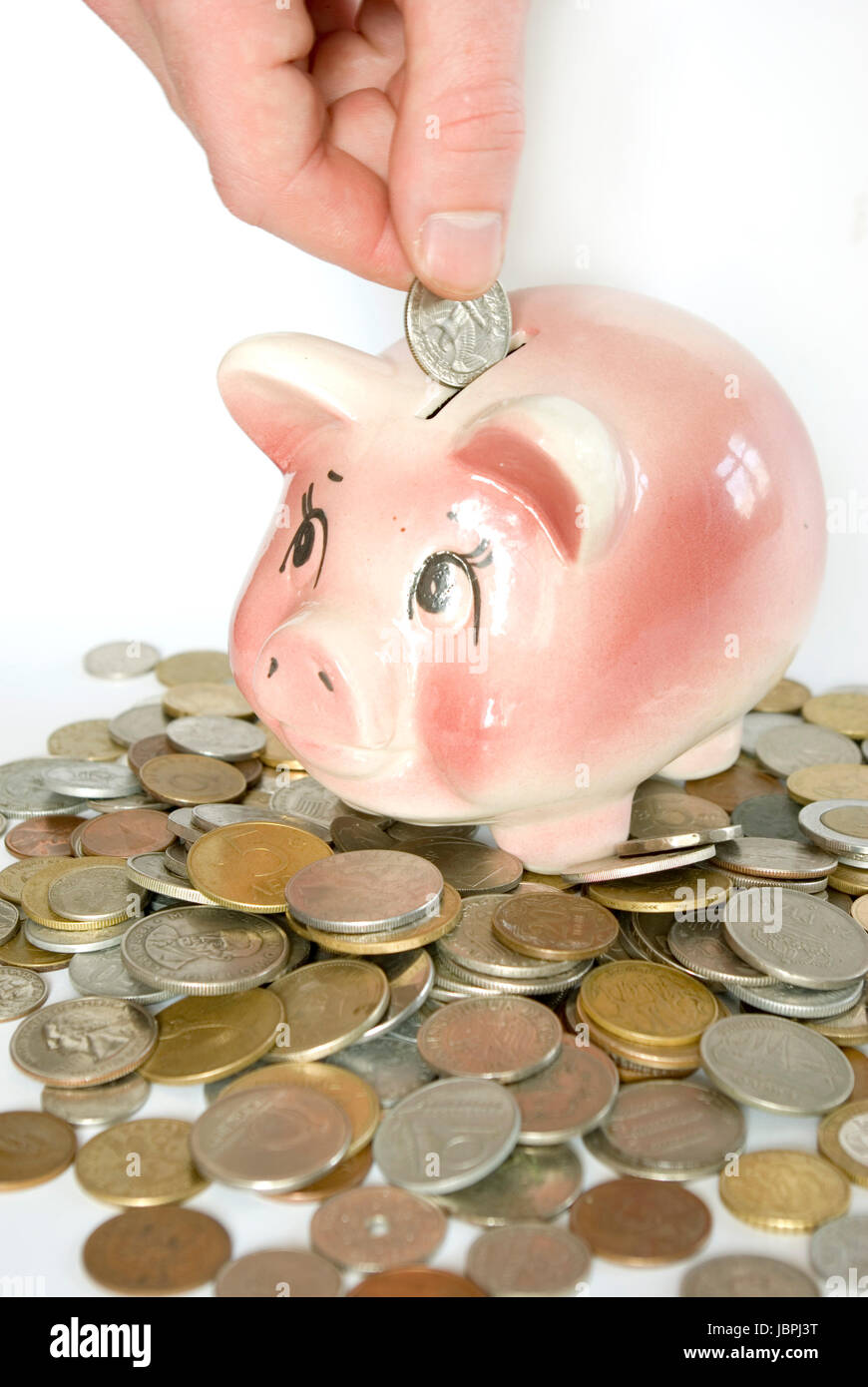 Hand inserting coin into piggy bank isolated on white Stock Photo - Alamy