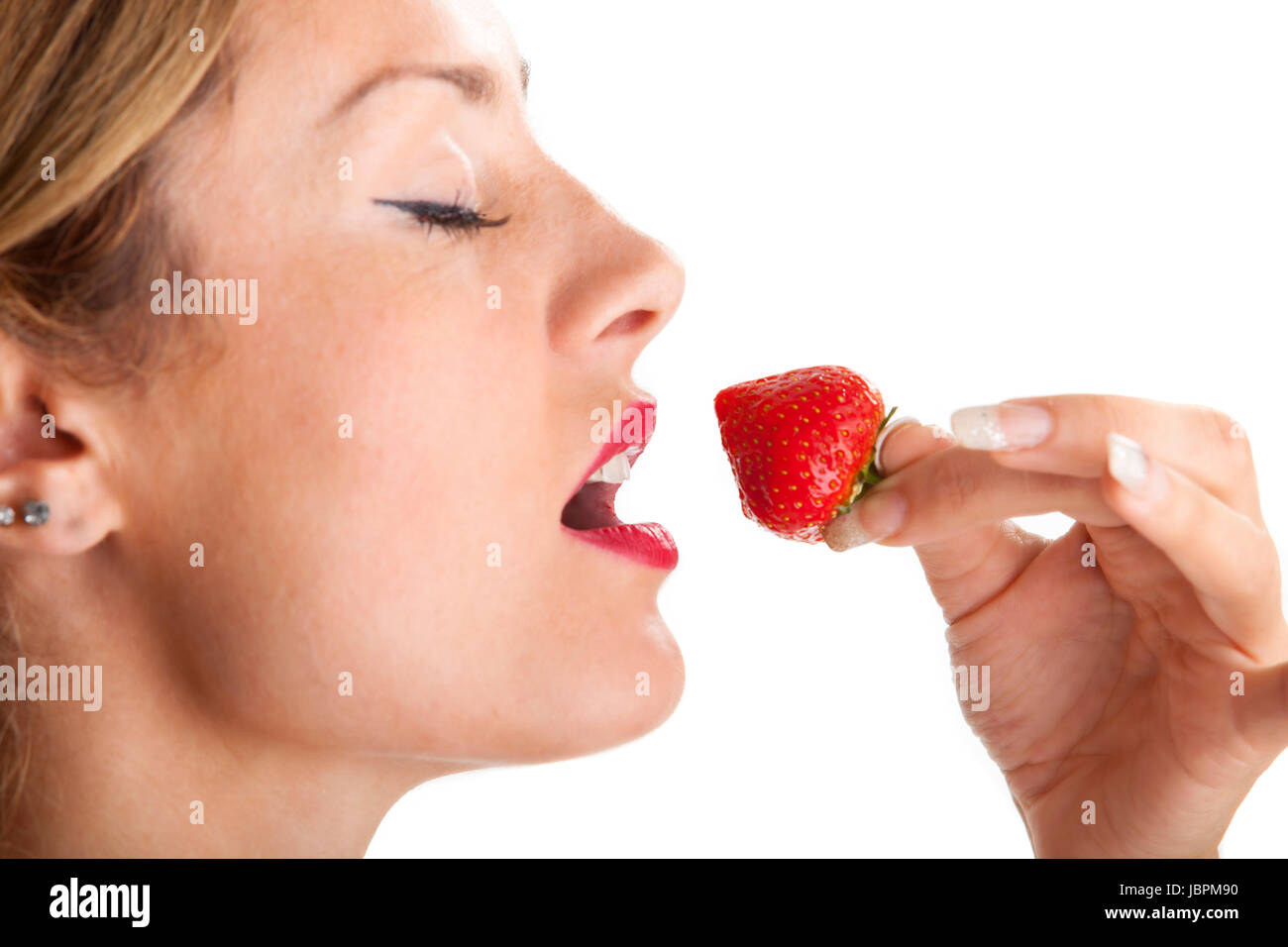 Frau isst eine Erdbeere Stock Photo