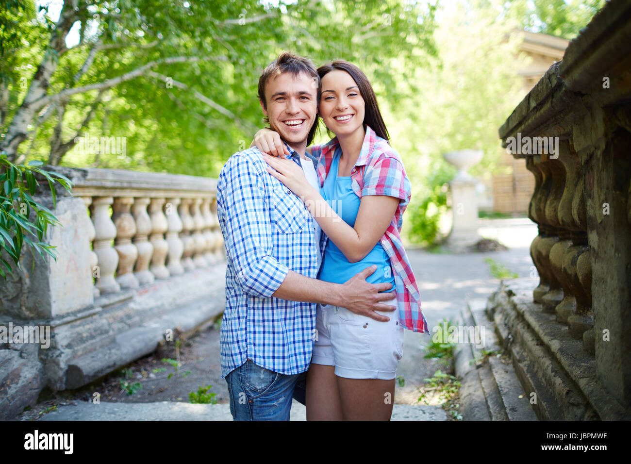 Portrait of travelers hugging and looking at camera Stock Photo - Alamy
