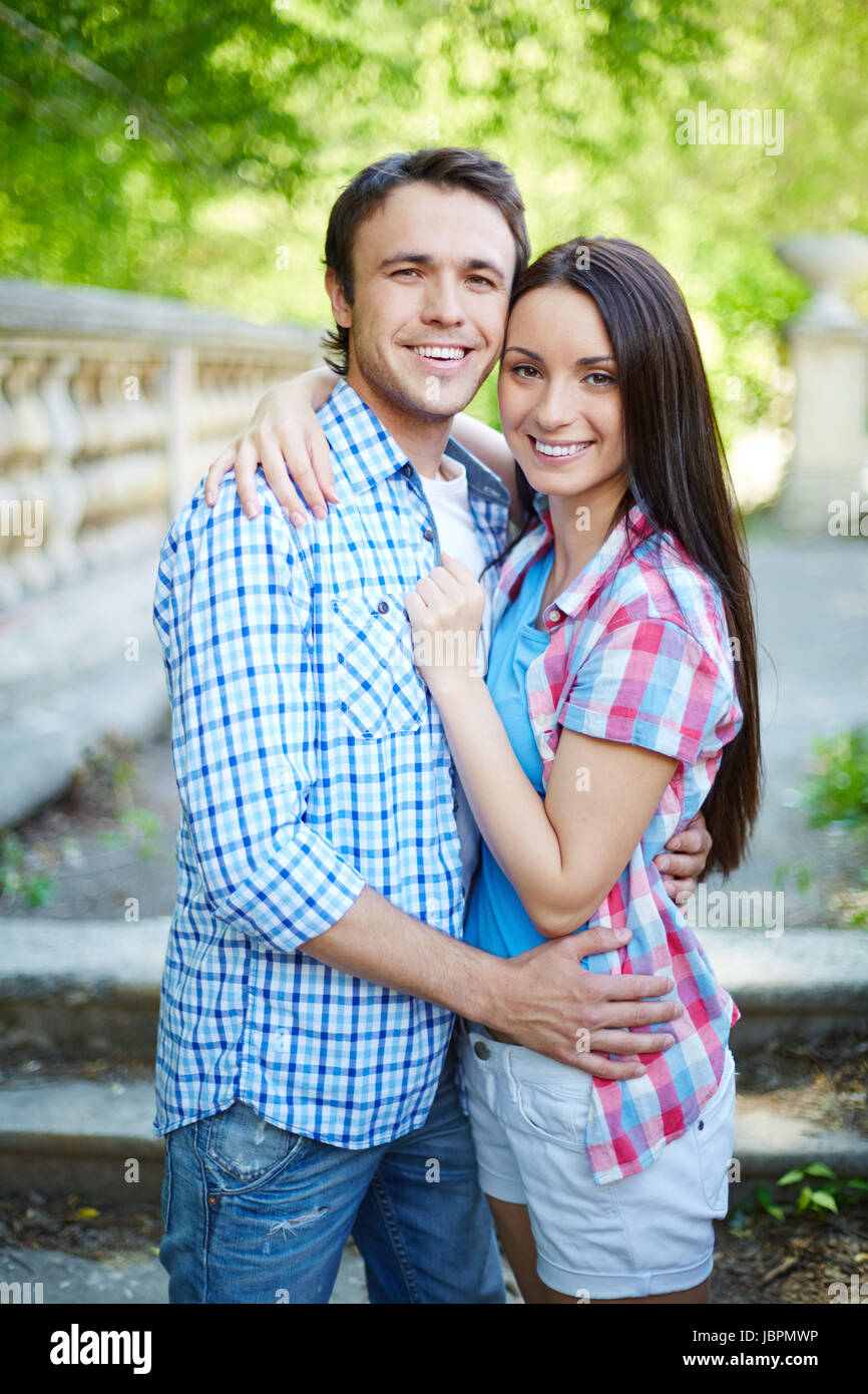 Portrait of young travelers hugging and looking at camera Stock Photo ...