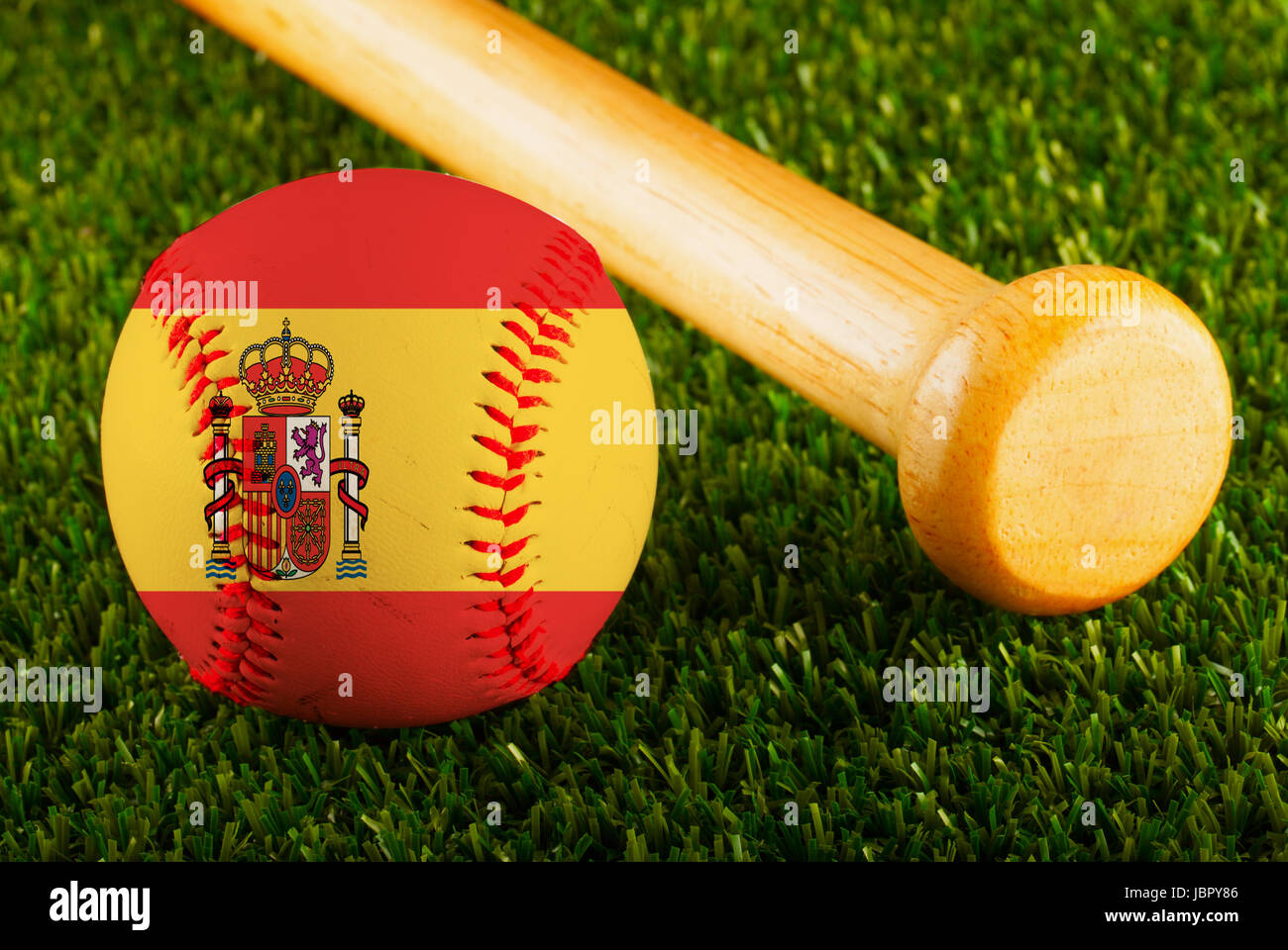 Baseball with Spain flag and bat over a background of green grass Stock Photo