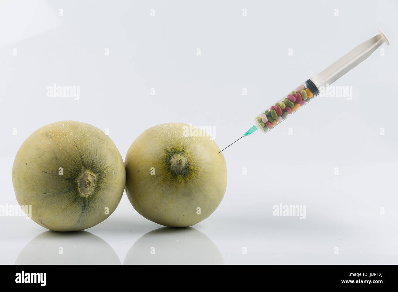 Cosmetic treatment for Female breasts metaphor melons and syringe with