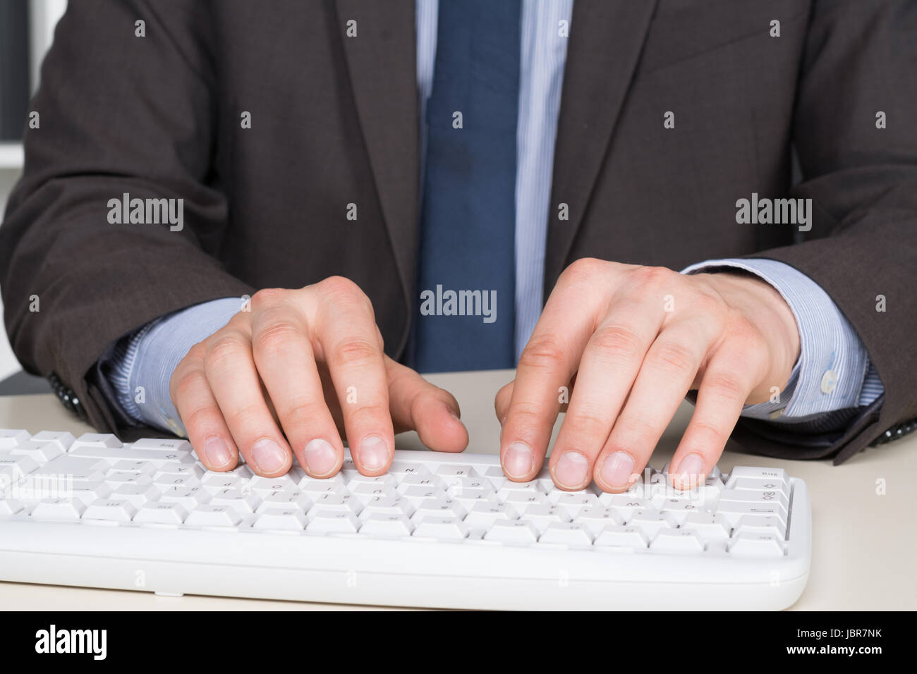 Geschäftsmann im Anzug tippt im Büro auf der Tastatur. Stock Photo