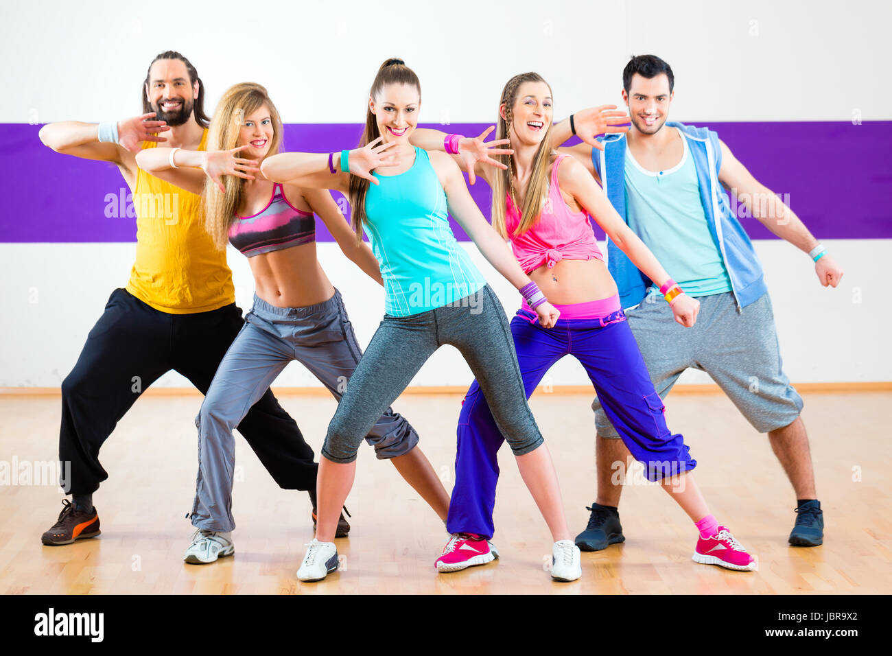 Group of men and women dancing zumba fitness choreography in dance ...