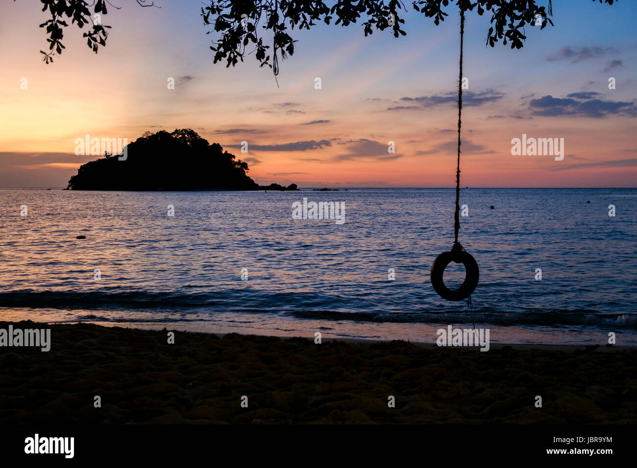 A tyre swing at sunset on Teluk Nipah Beach, Pangkor Island (Pulau Pangkor), Malaysia. Stock Photo