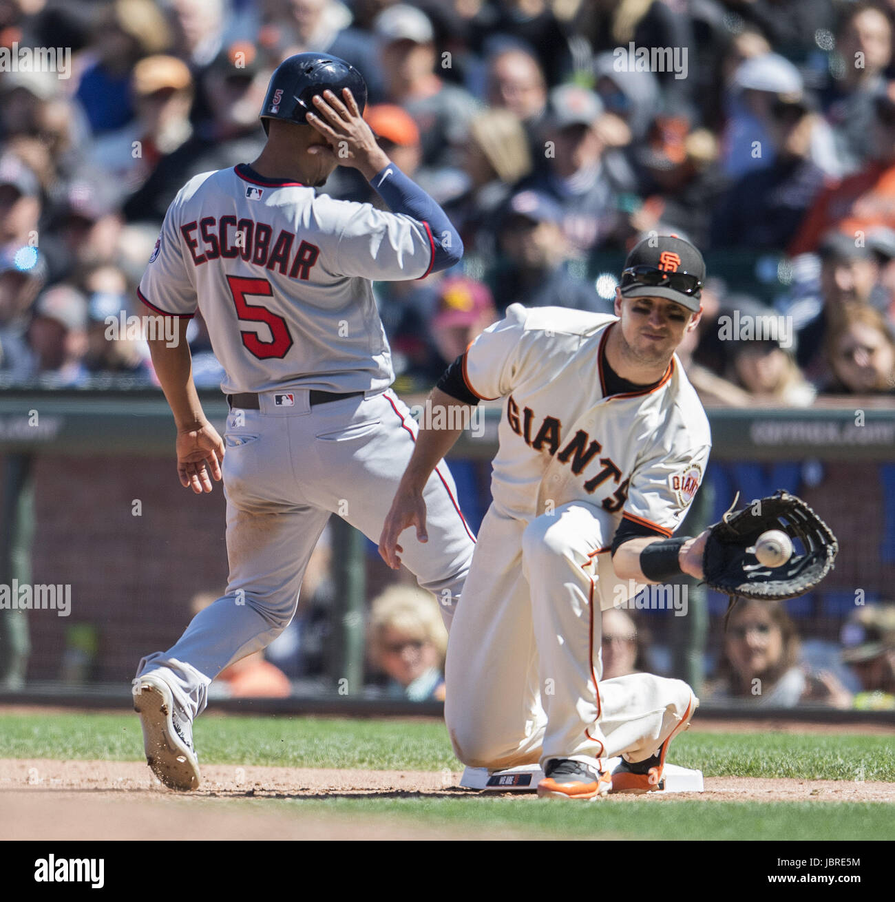 San Francisco, California, USA. 11th June, 2017. San Francisco Giants catcher Buster Posey (28) takes the throw to keep Minnesota Twins third baseman Eduardo Escobar (5) on first base, during a MLB baseball game between the Minnesota Twins and the San Francisco Giants on ''Dog Days of Summer'' at AT&T Park in San Francisco, California. Valerie Shoaps/CSM/Alamy Live News Stock Photo