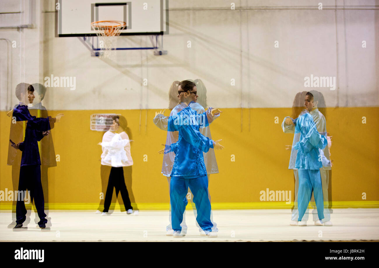 (170612) -- LAVAGNA, June 12, 2017 (Xinhua) -- Students practice Chinese martial arts at the 'Center for the studies of Oriental Cultures' gymnasium in Lavagna, Italy, May 8, 2017 (Multiple exposure).  Ghinolfi, a retired bank manager at age of 75 now, has always been passionate about sports.  After seeing a presentation of Chinese martial arts in Genova and meeting Yang Li, a visiting scholar from Beijing Sport University in 1984, he was fascinated by Chinese martial arts and had kept practising it for decades.  According to Ghinolfi, he usually gets up early at 5:30 in the morning, then star Stock Photo