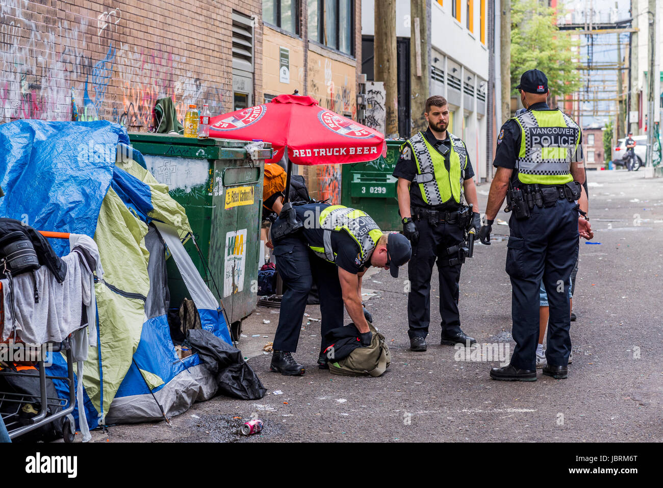 Police handcuff and detain man in alleyway, Hastings Street, DTES, Vancouver, British Columbia, Canada. Credit: Michael Wheatley/Alamy Live News Stock Photo
