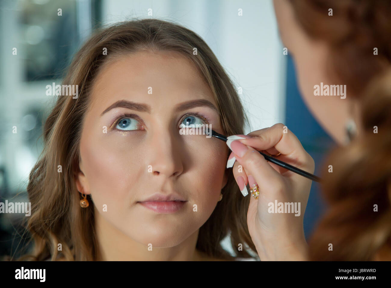Make up artist doing professional makeup of young woman Stock Photo Alamy