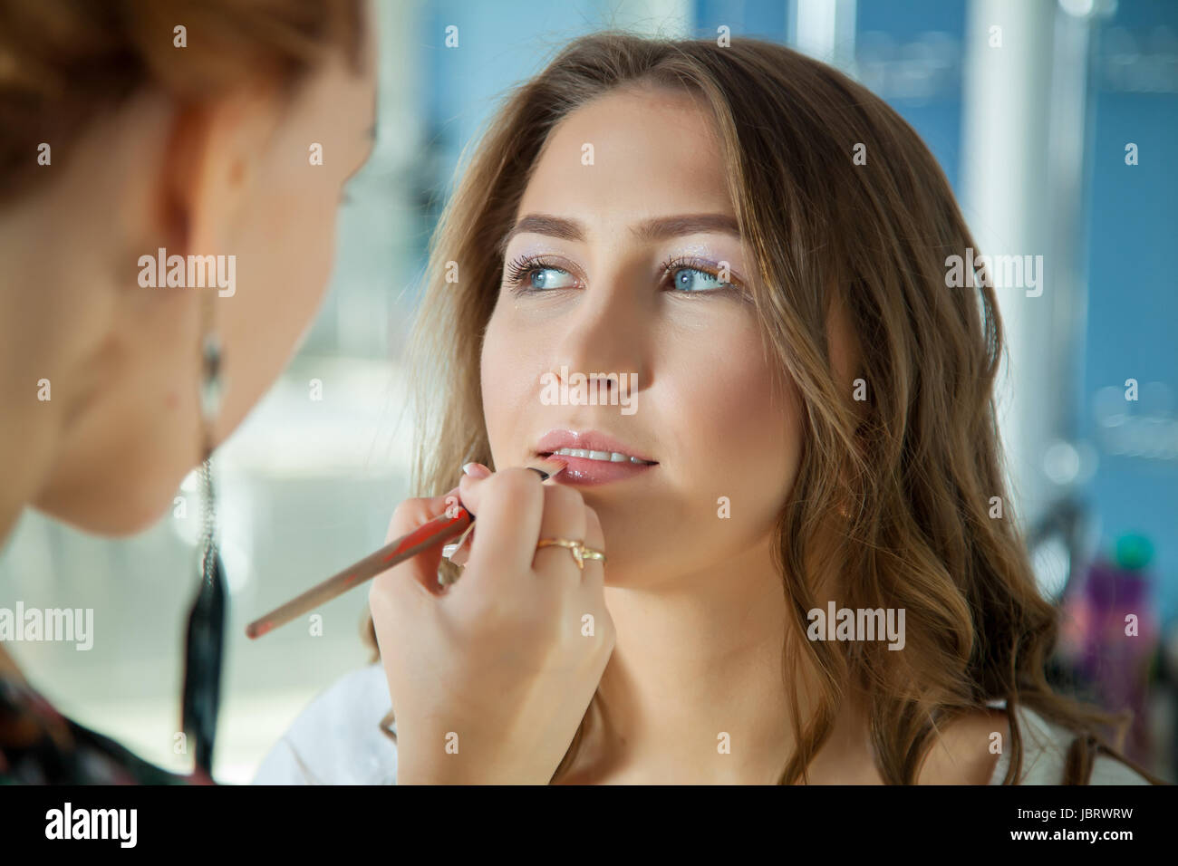 Make up artist doing professional makeup of young woman Stock Photo Alamy