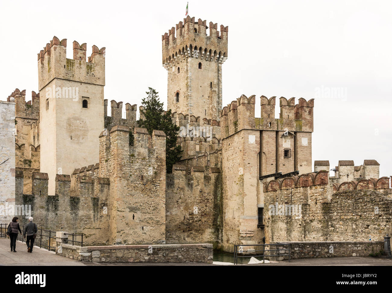 SIRMIONE, ITALY - APRIL 23: Tourists at Scaliger Castle in Sirmione, Italy on April 23, 2014. The castle was built in the 13th century. Foto taken from Piazza Castello Stock Photo
