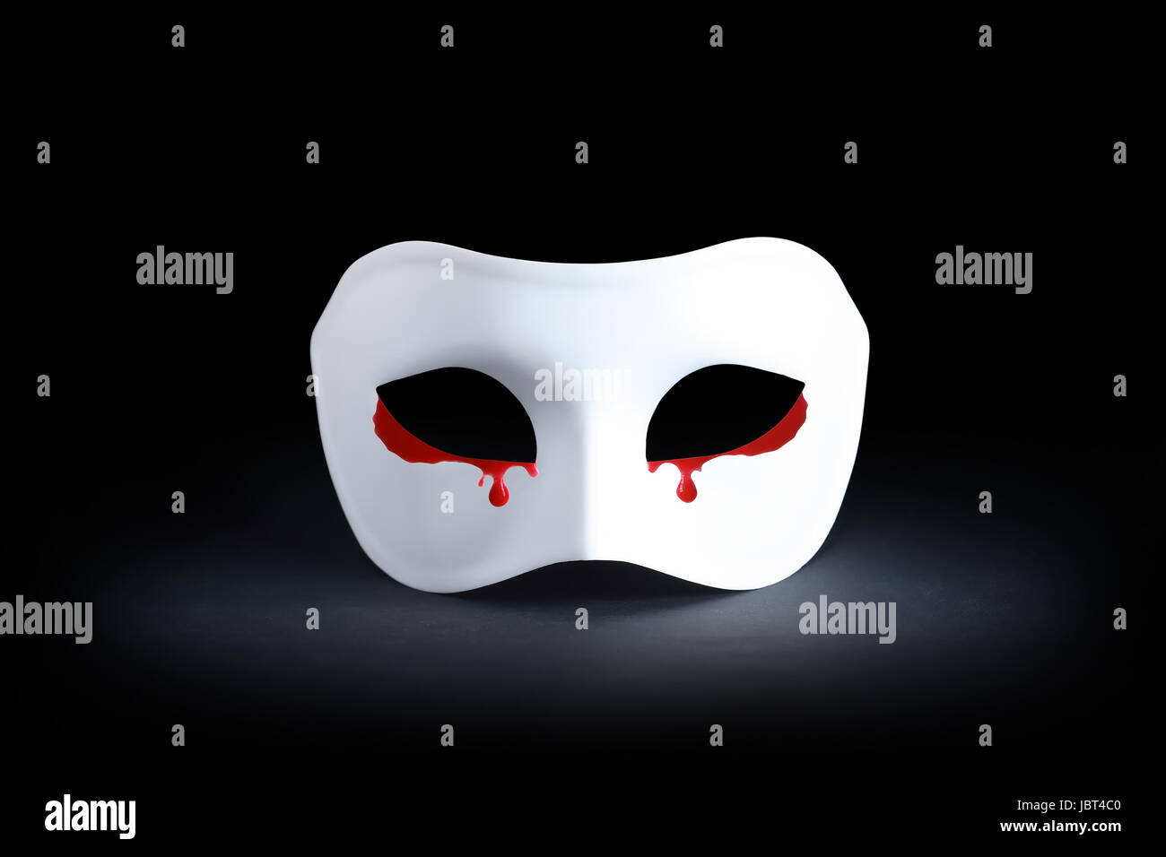 Suffering concept. White mask with bloody tears on black background Stock Photo