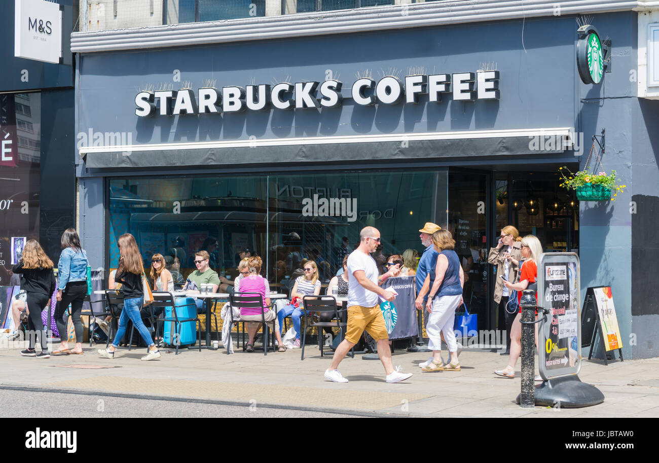 Starbucks Coffee shop. People sitting outside a Starbucks coffee shop in Summer in Brighton, East Sussex, England, UK. Stock Photo
