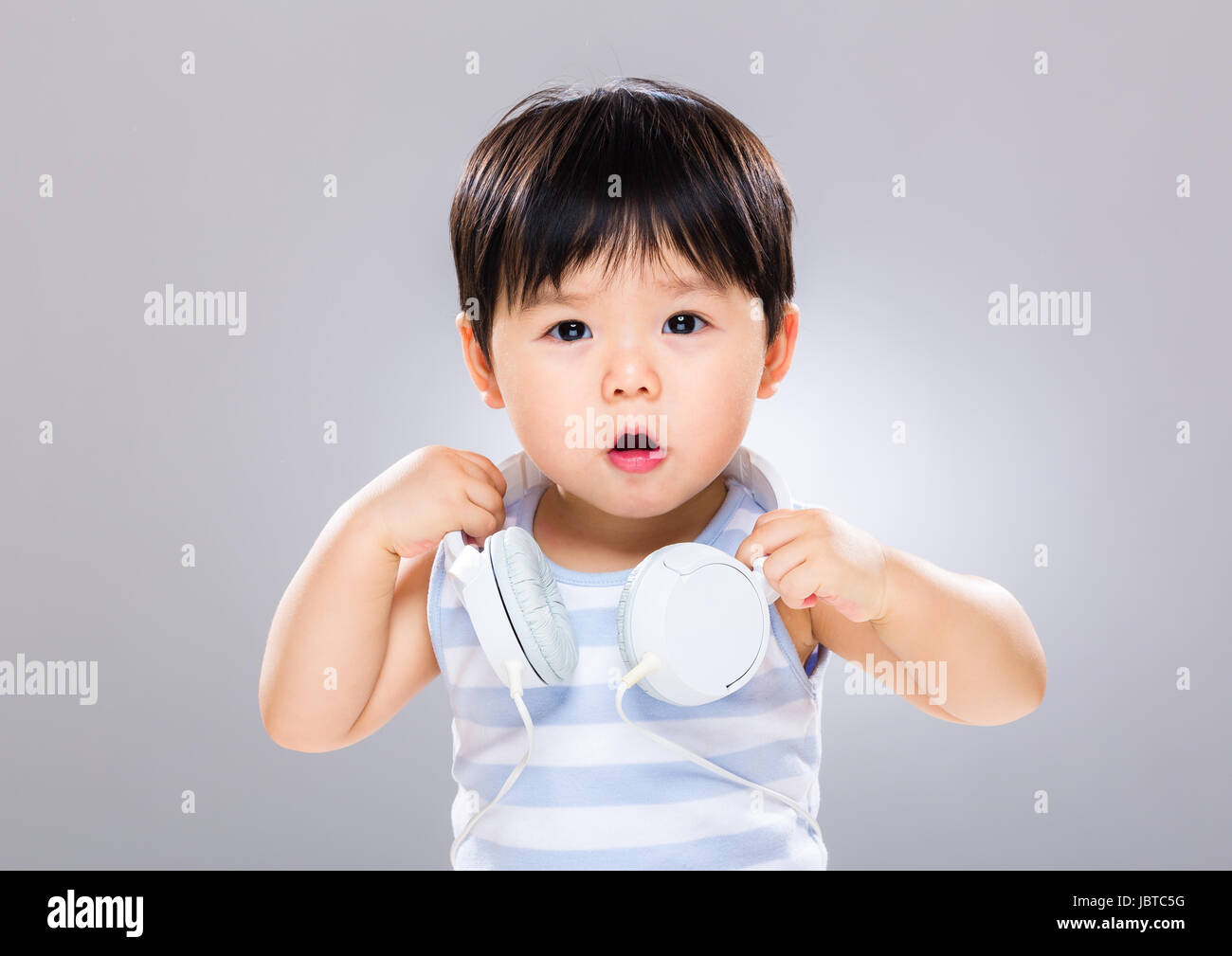 Baby boy holding headphone Stock Photo Alamy