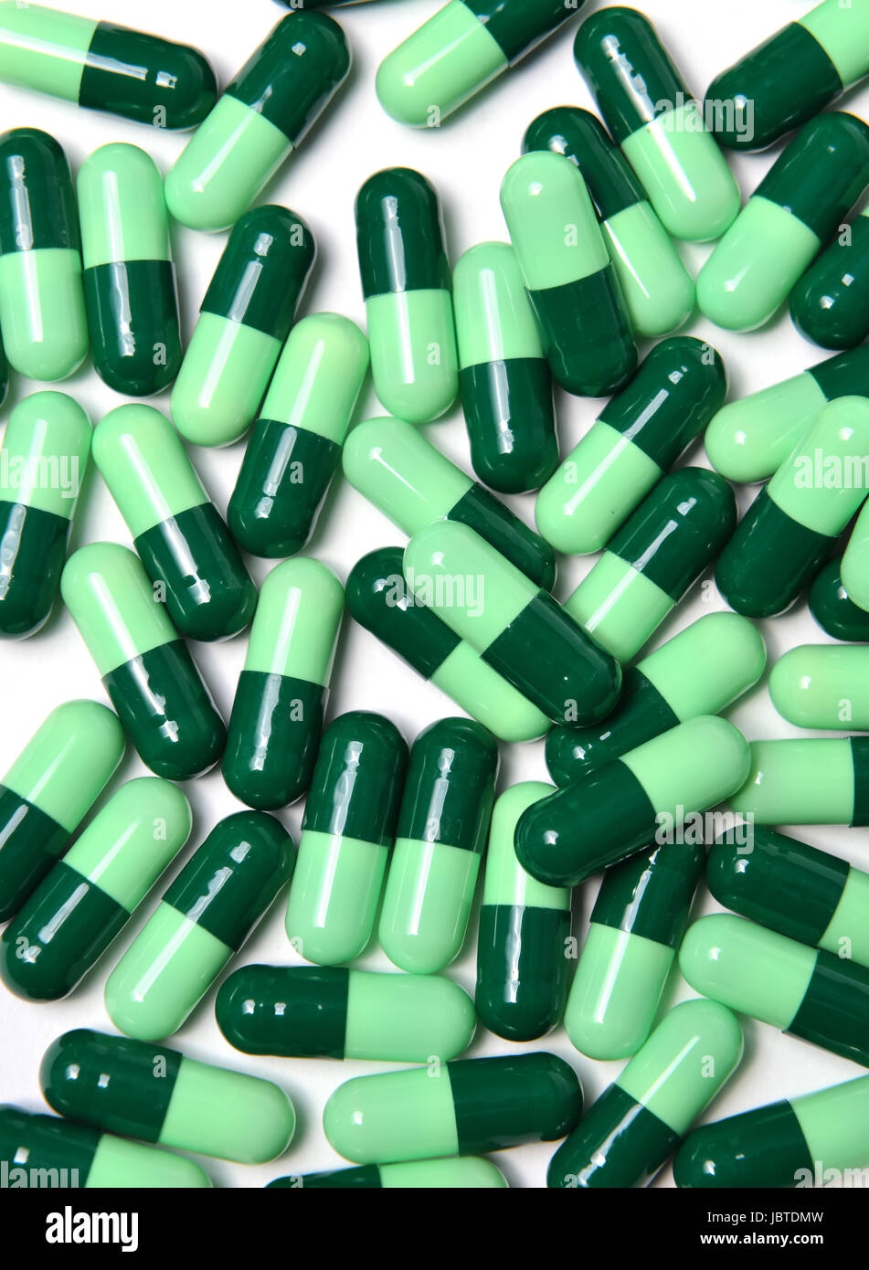 group of green capsule medicine on white background Stock Photo - Alamy