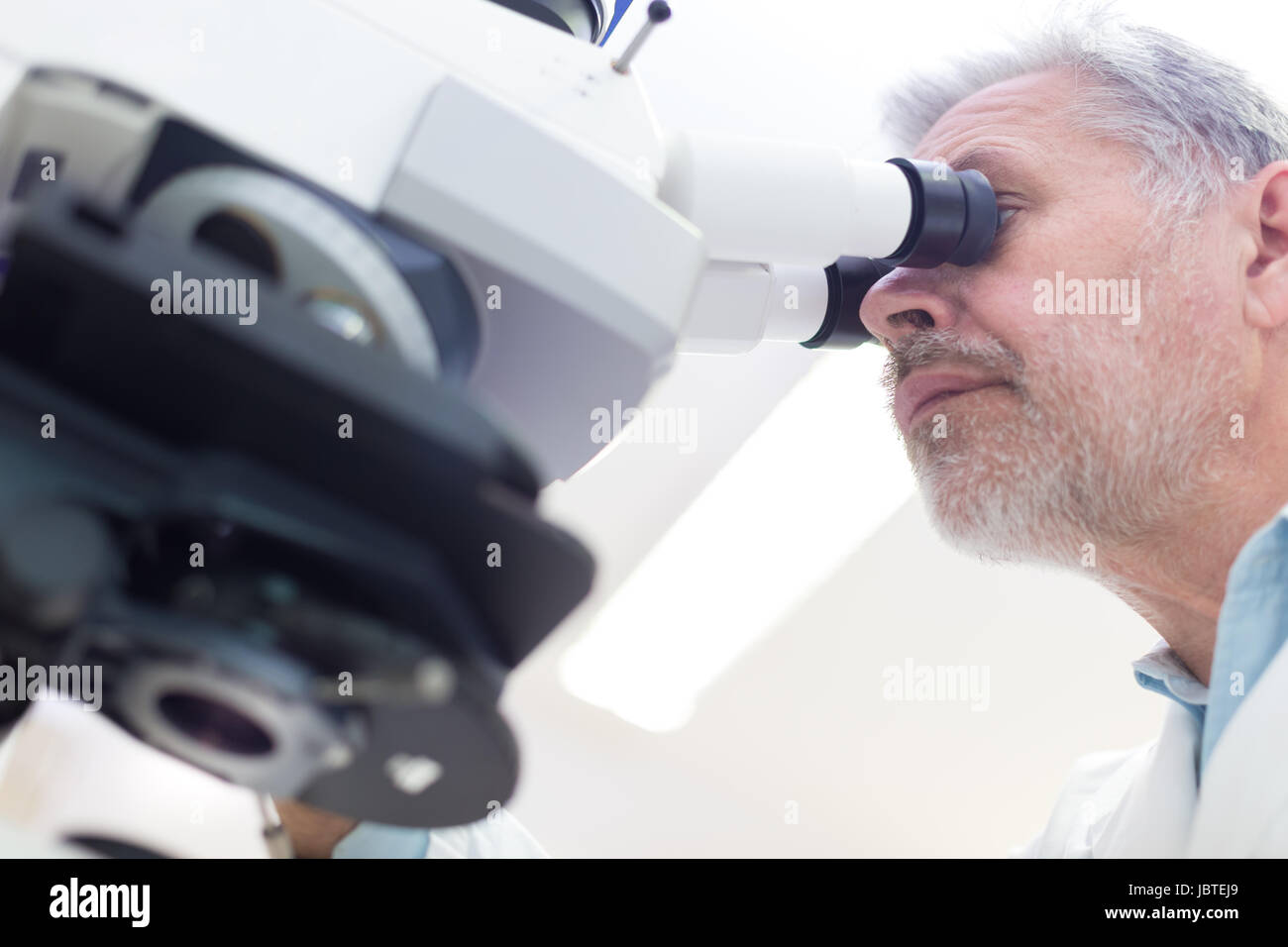 Senior head scientist microscoping in the life science research