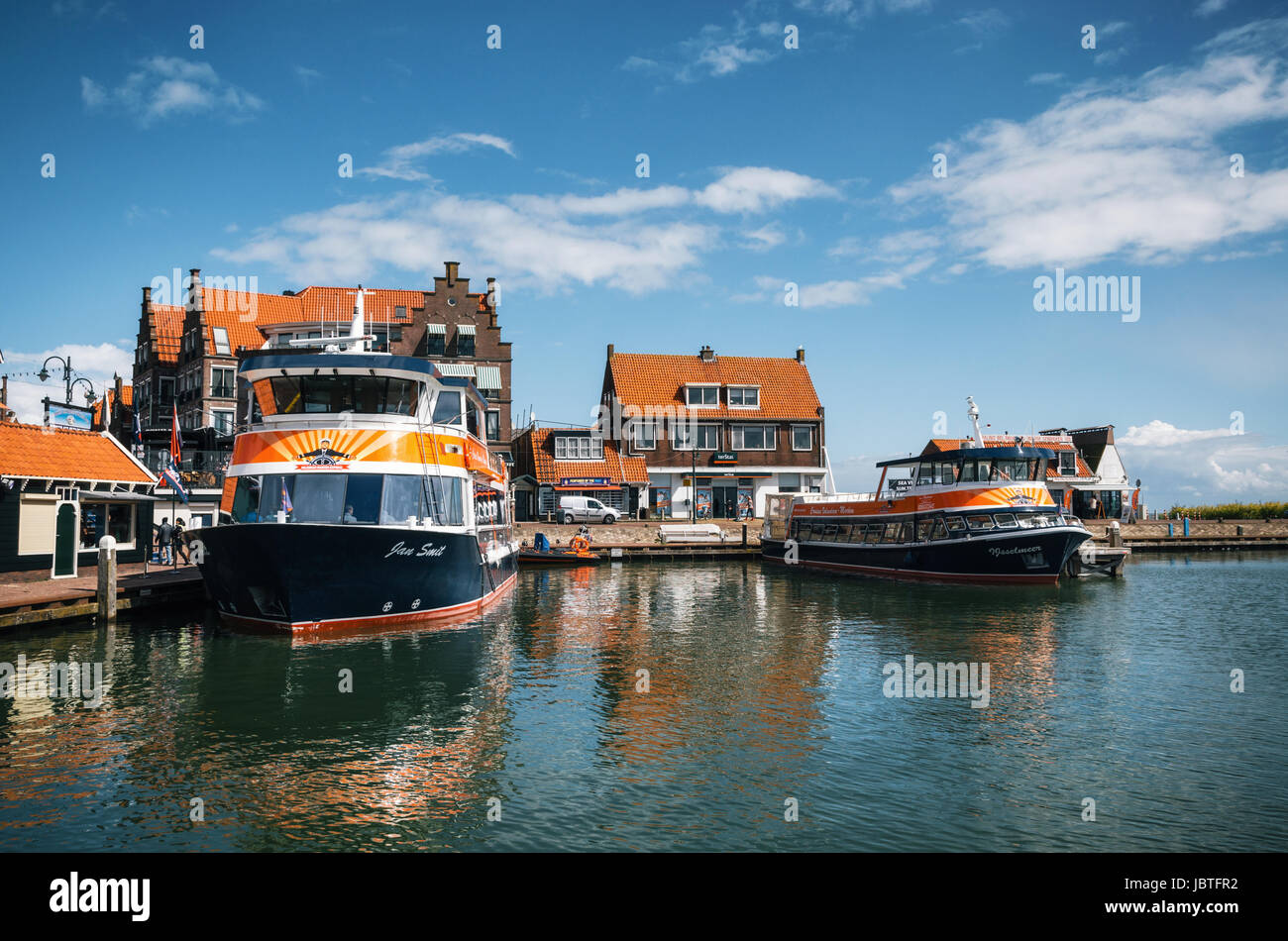 Volendam, Netherlands - 26 April, 2017: Harbor of Volendam with colorful tourist boats and promenade at sunny day, Netherlands. Volendam is a popular  Stock Photo