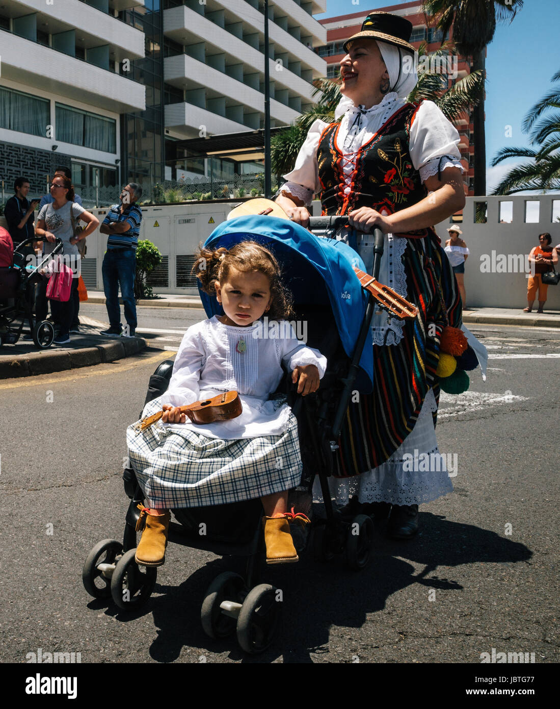 Puerto de la Cruz, Tenerife, Canary Islands - May 30, 2017: A little girl  dressed in traditional clothes sits in a stroller and holds the canary  guita Stock Photo - Alamy