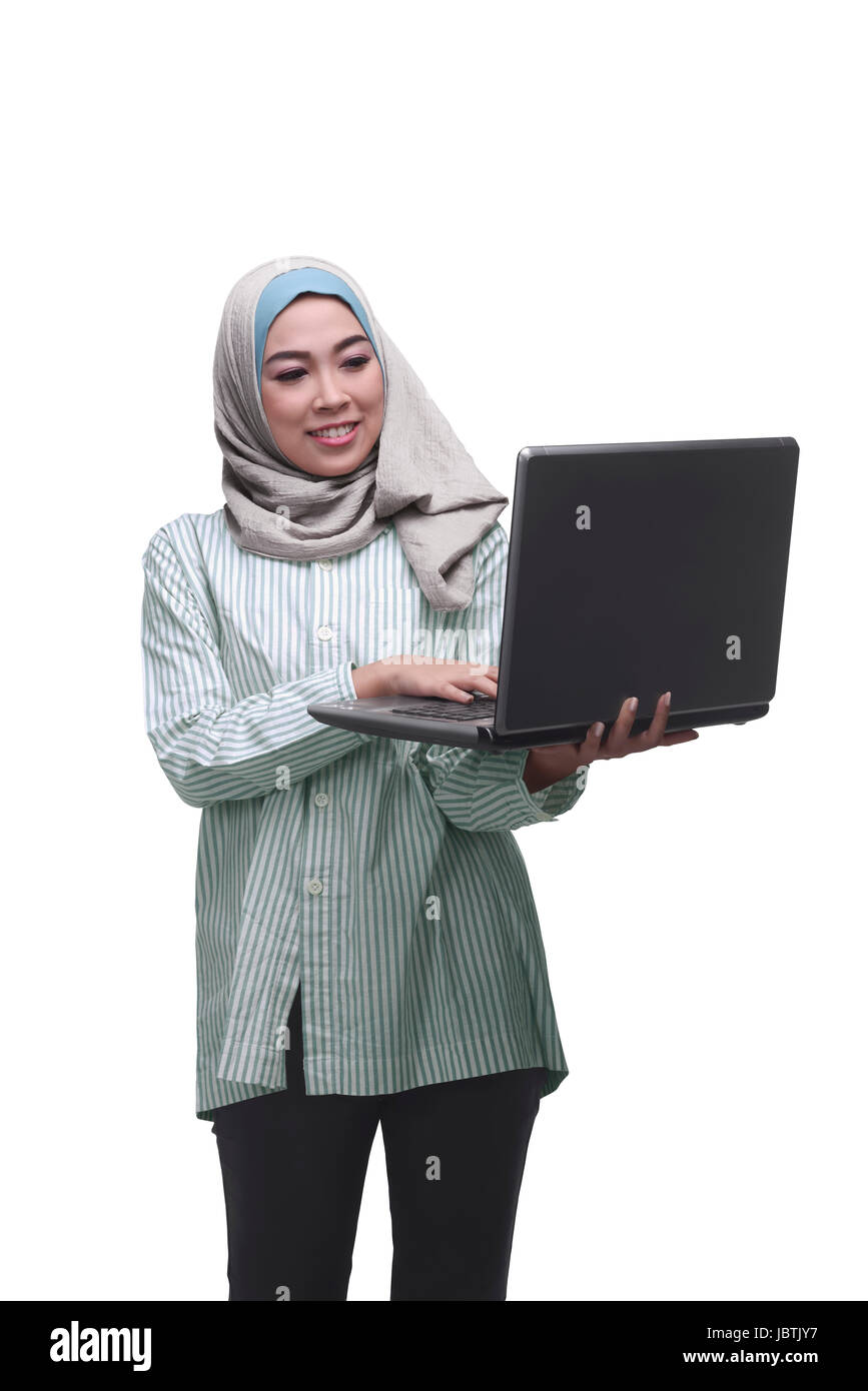 Beautiful asian muslim woman holding while typing on laptop isolated ...