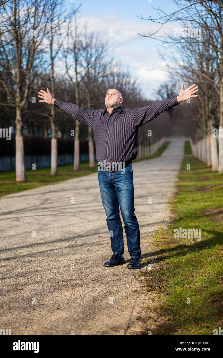 Mann mittleren Altres Rentner mit ausgebreiteten Armen genießt die frische Luft Stock Photo