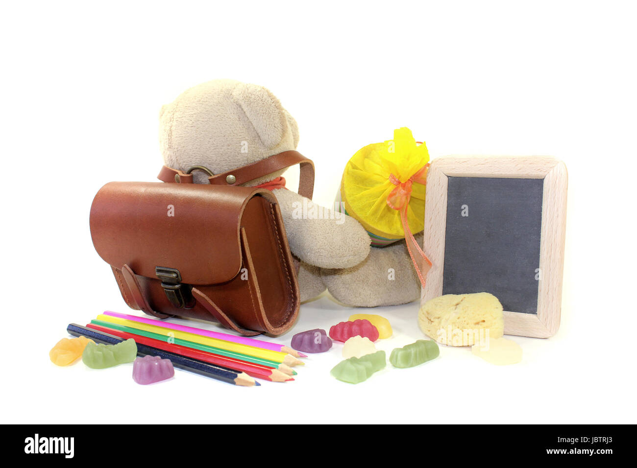 Teddybär mit Schultüte, Mappe, Stiften und Tafel vor hellem Hintergrund  Stock Photo - Alamy