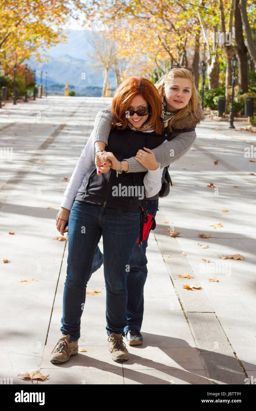 Two young happy women having fun in park Stock Photo - Alamy