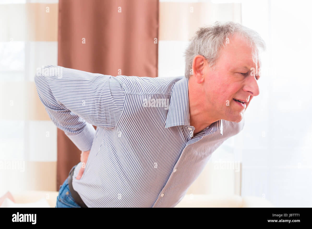 Old man holding back because of lumbago Stock Photo - Alamy