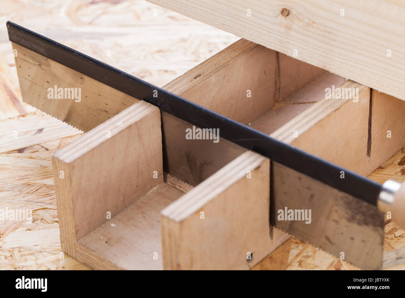 Holz mit Winkelschneider und Säge in einer Werkstatt nahaufnahme detail Stock Photo