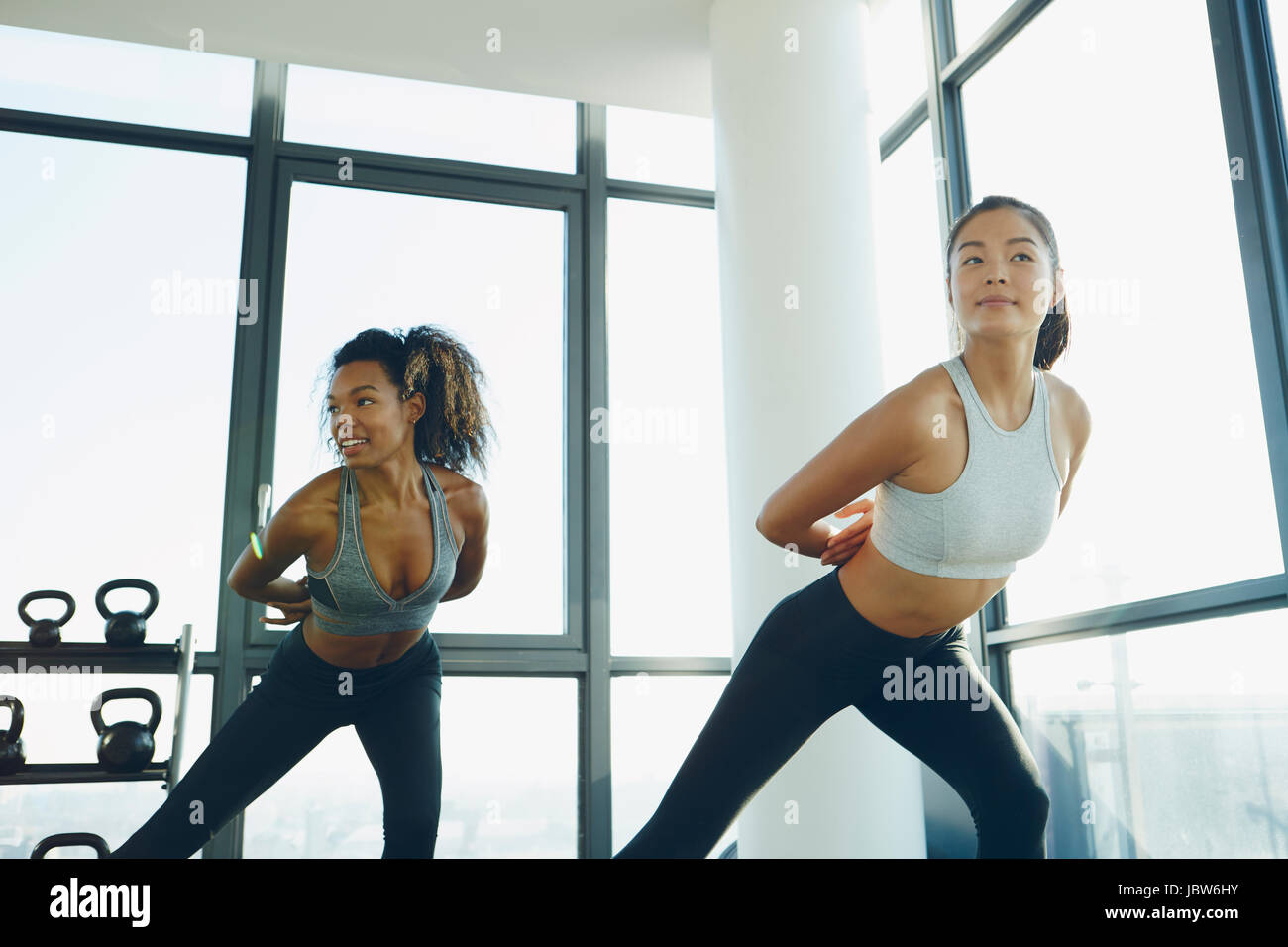 Two young women exercising in gym, doing aerobic workout Stock Photo