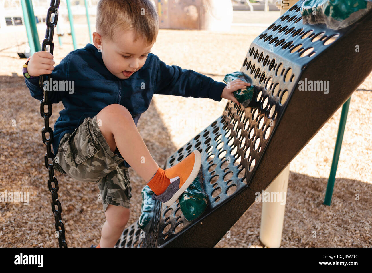 Boy climbing on playground climbing frame Stock Photo Alamy