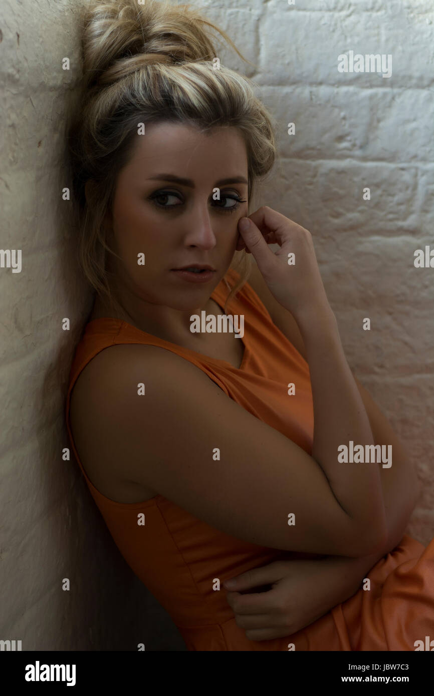 Worried young woman sitting on the floor looking away Stock Photo - Alamy