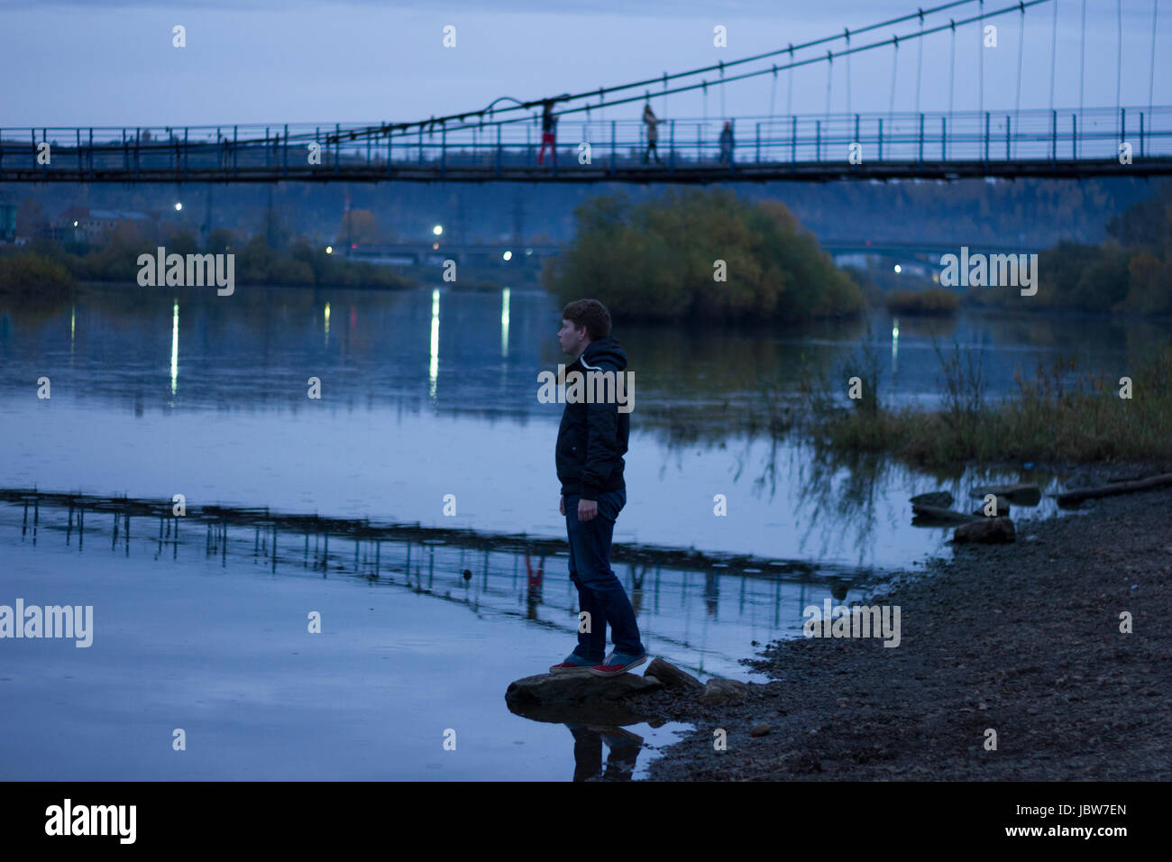 Young man by pedestrian bridge, Chusovoy, Russia Stock Photo