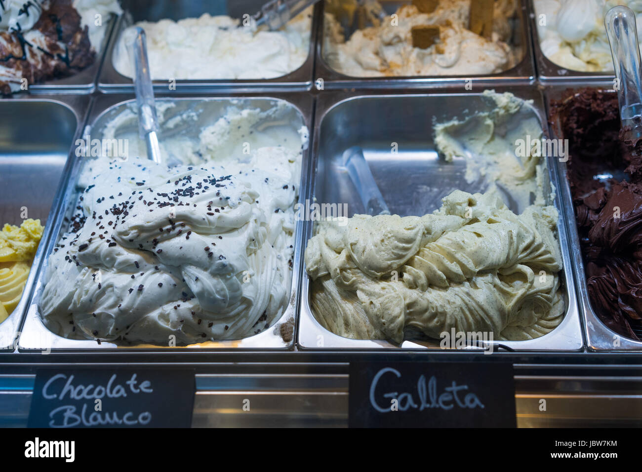 Italian ice cream on display in metal tubs at an ice cream parlour in with a variety of