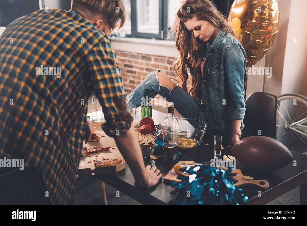 man and woman cleaning messy room after party Stock Photo