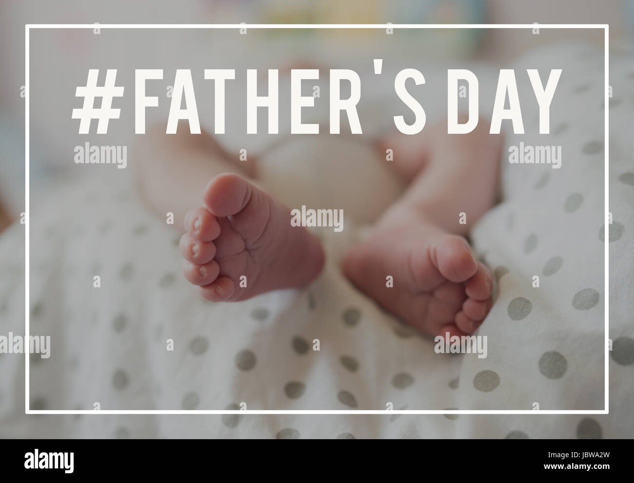 Feet of unrecognizable baby lying on bed. Fathers day. Stock Photo