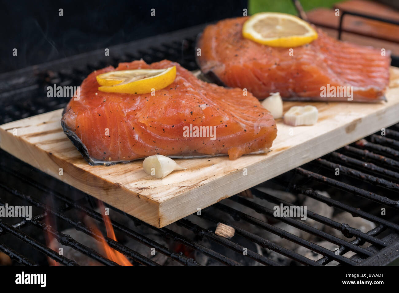 cedar plank salmon with lemon cooking on grill Stock Photo - Alamy