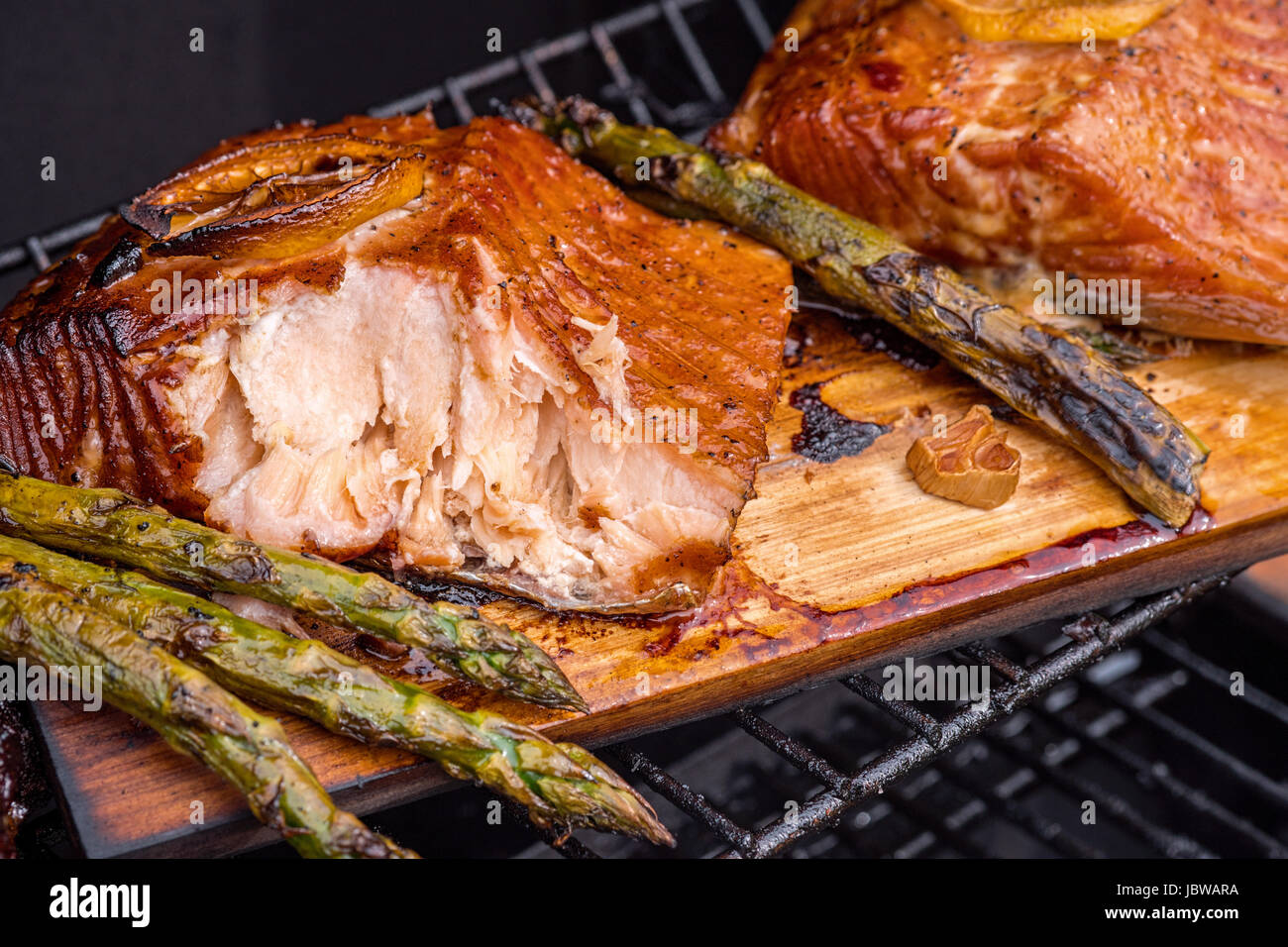 cedar plank salmon with lemon cooking on grill Stock Photo - Alamy