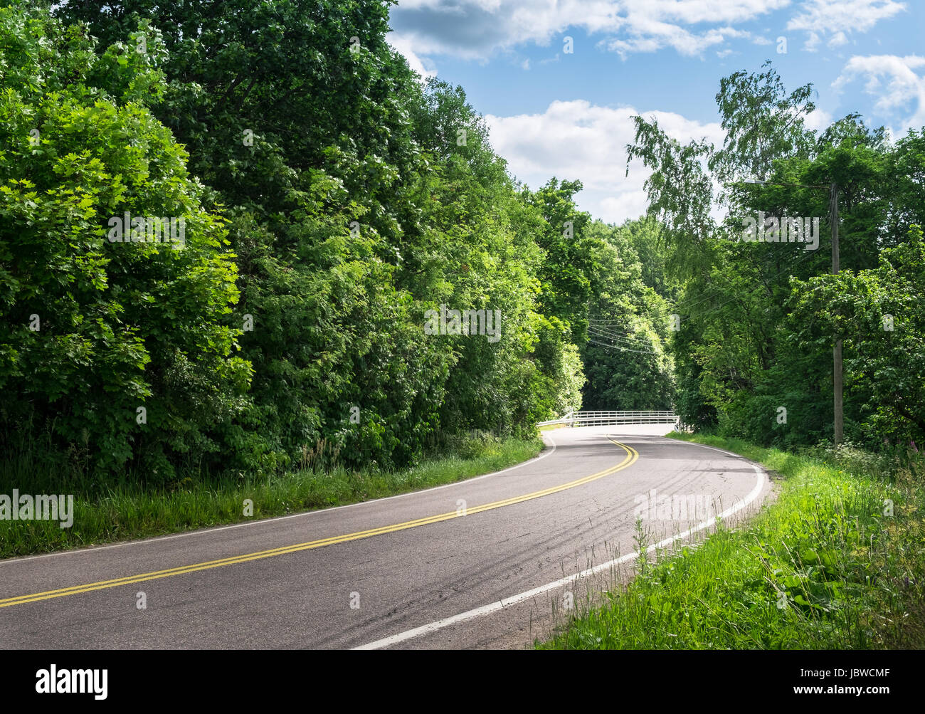 Landscape with curvy road at bright summer day Stock Photo