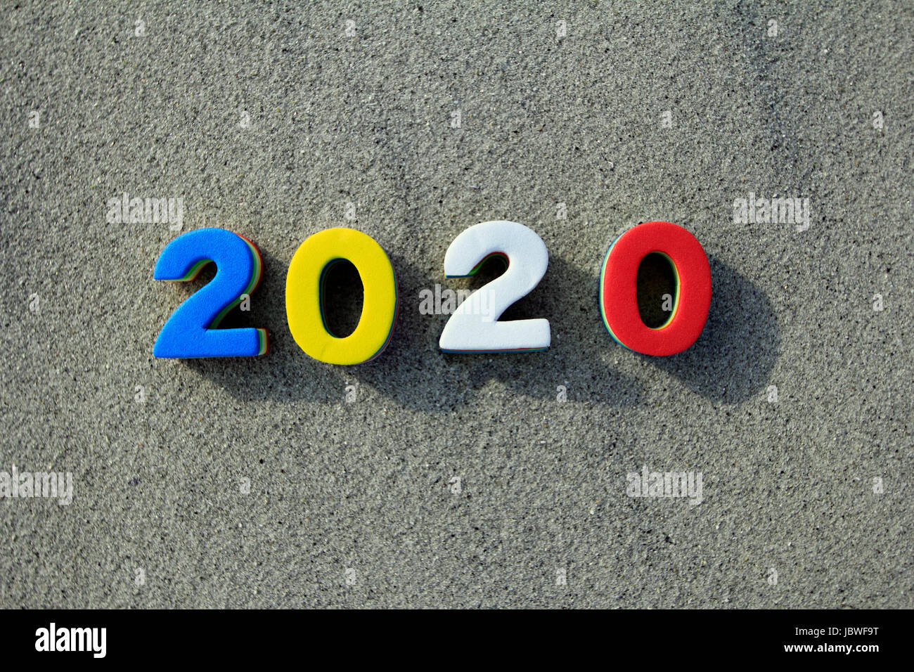Year 2020 marked with toy numbers on a sandy beach Stock Photo