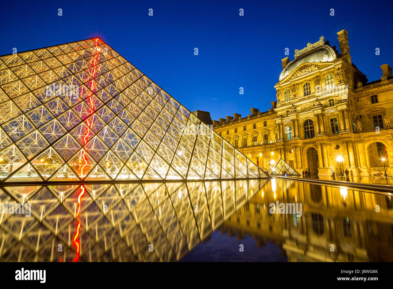 Paris - June 18: Louvre museum at dusk on June 18, 2014 in Paris. This is one of the most popular tourist destinations in France displayed over 60,000 square meters of exhibition space.. Stock Photo