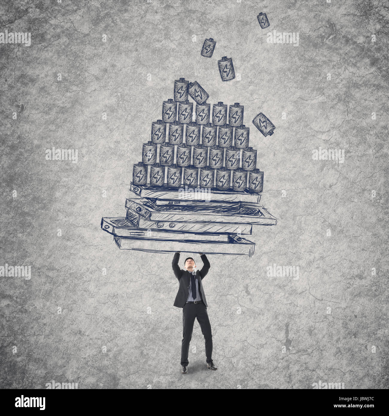 Young man holding mobile phones and batteries, concept of energy waste, power, technology problems etc. Stock Photo