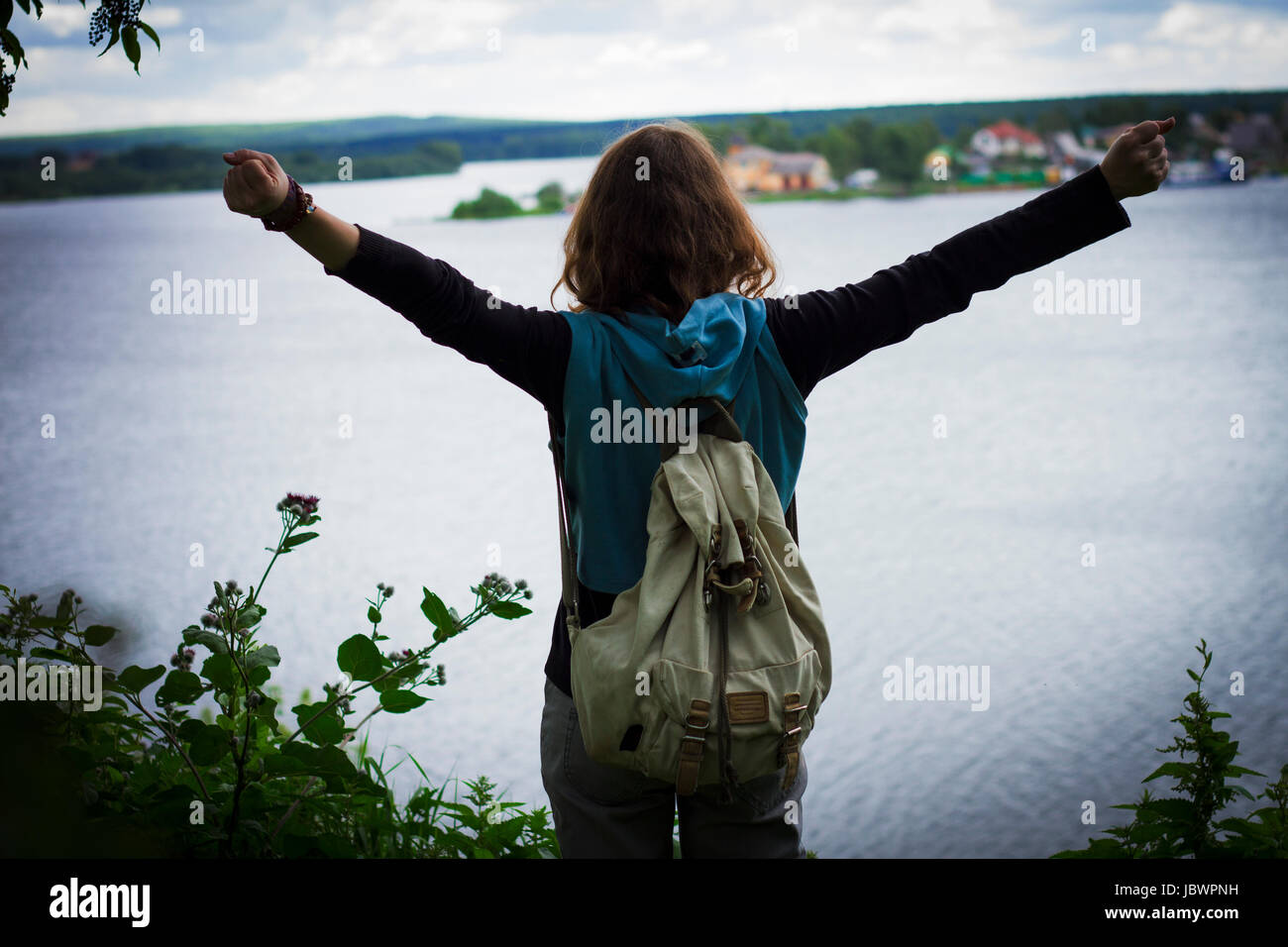 Rear view of woman with arms raised looking away, Nizny Tagil, Sverdlovsk, Russia Stock Photo