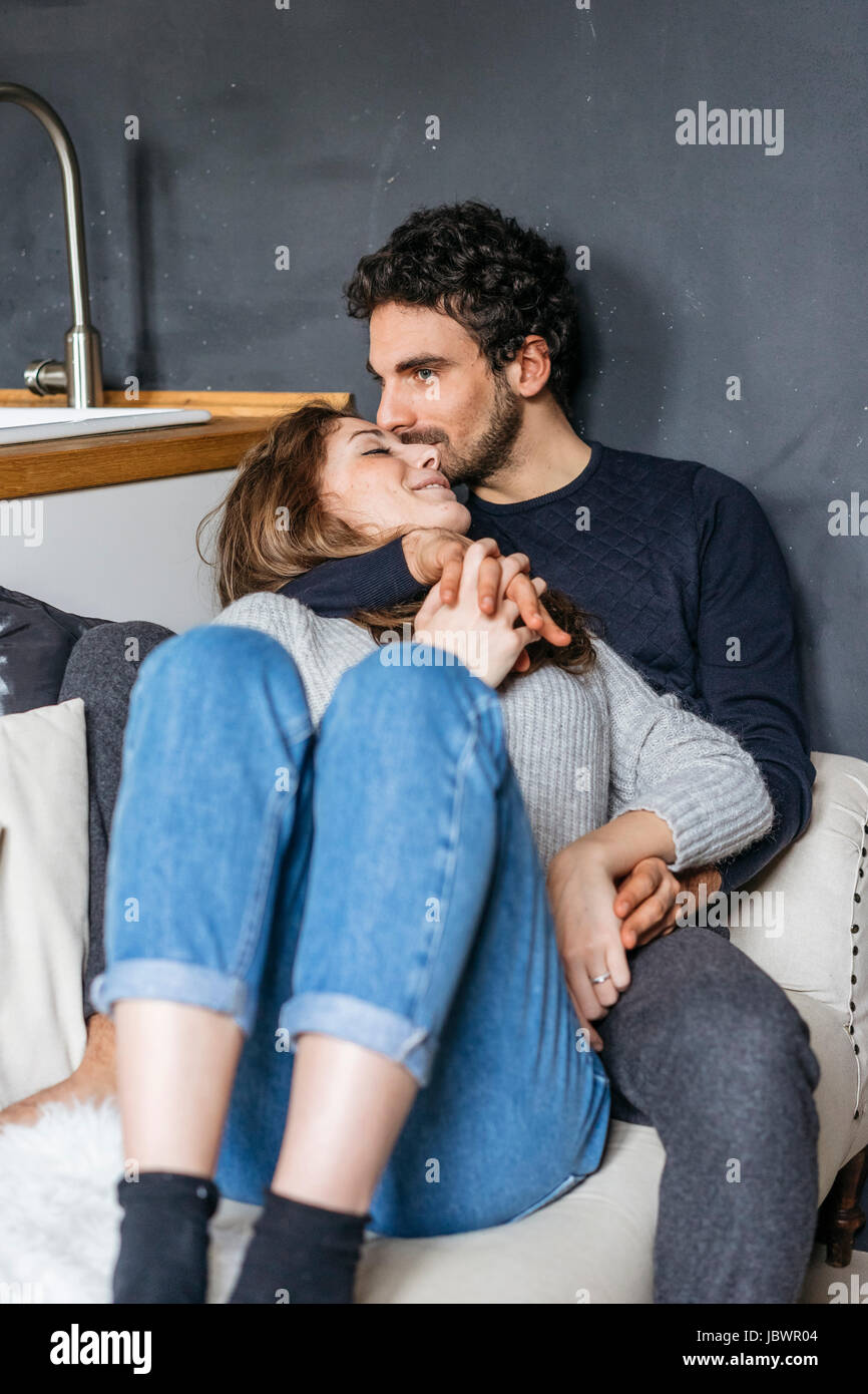 Romantic young couple reclining on sofa Stock Photo Alamy