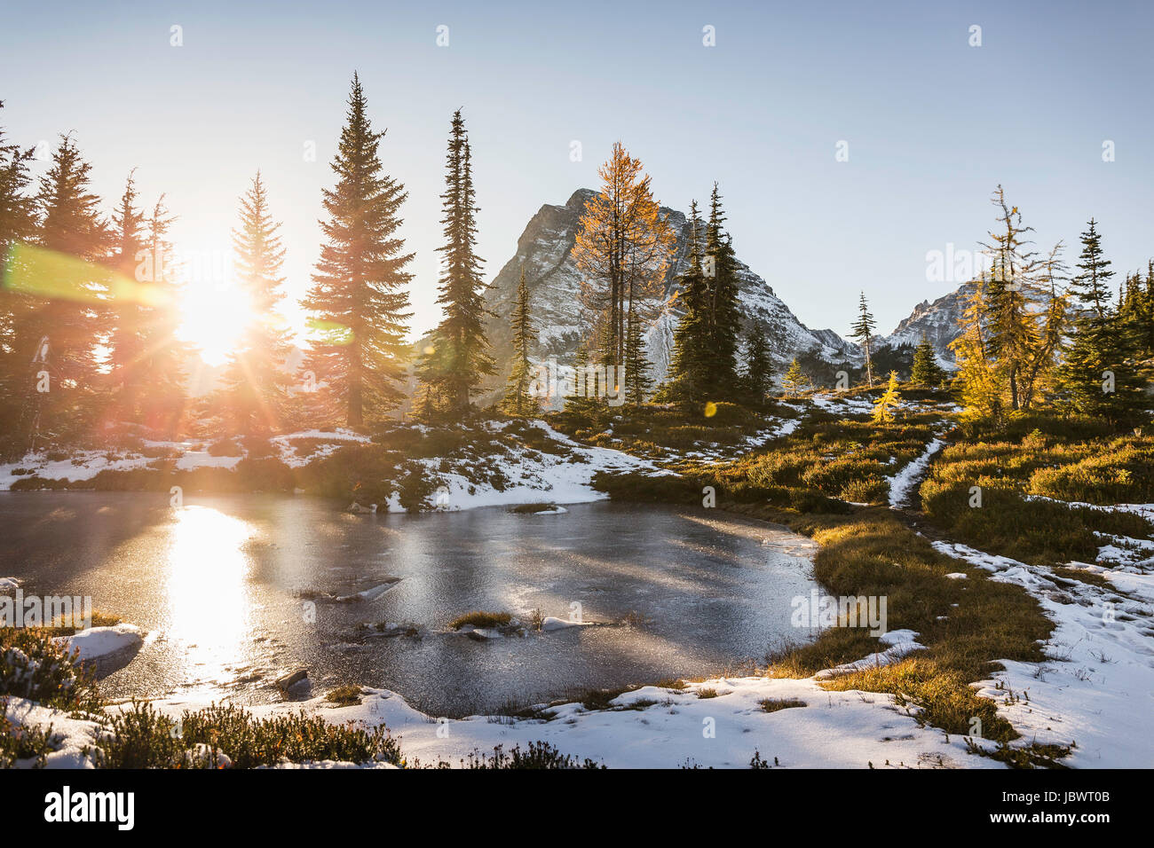 Sunlight through trees by lake, cascade mountain range, Diablo, Washington, USA Stock Photo