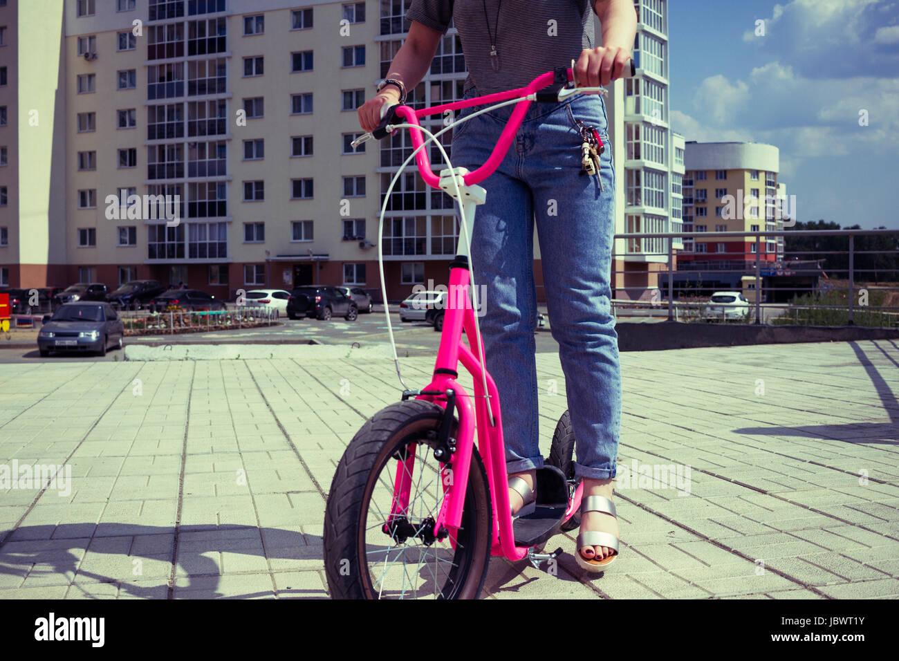 Cropped view of woman on pink scooter Stock Photo