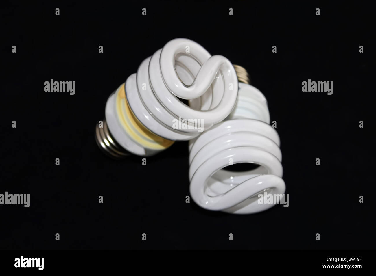 Closeup of two fluorescent light bulbs isolated on a black background