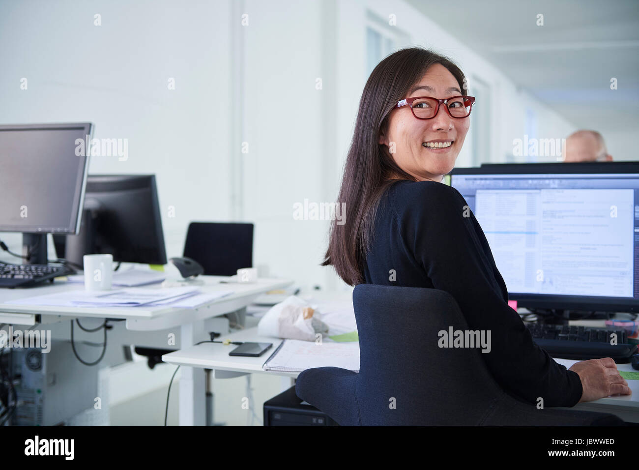 Woman working in office, using computer Stock Photo - Alamy