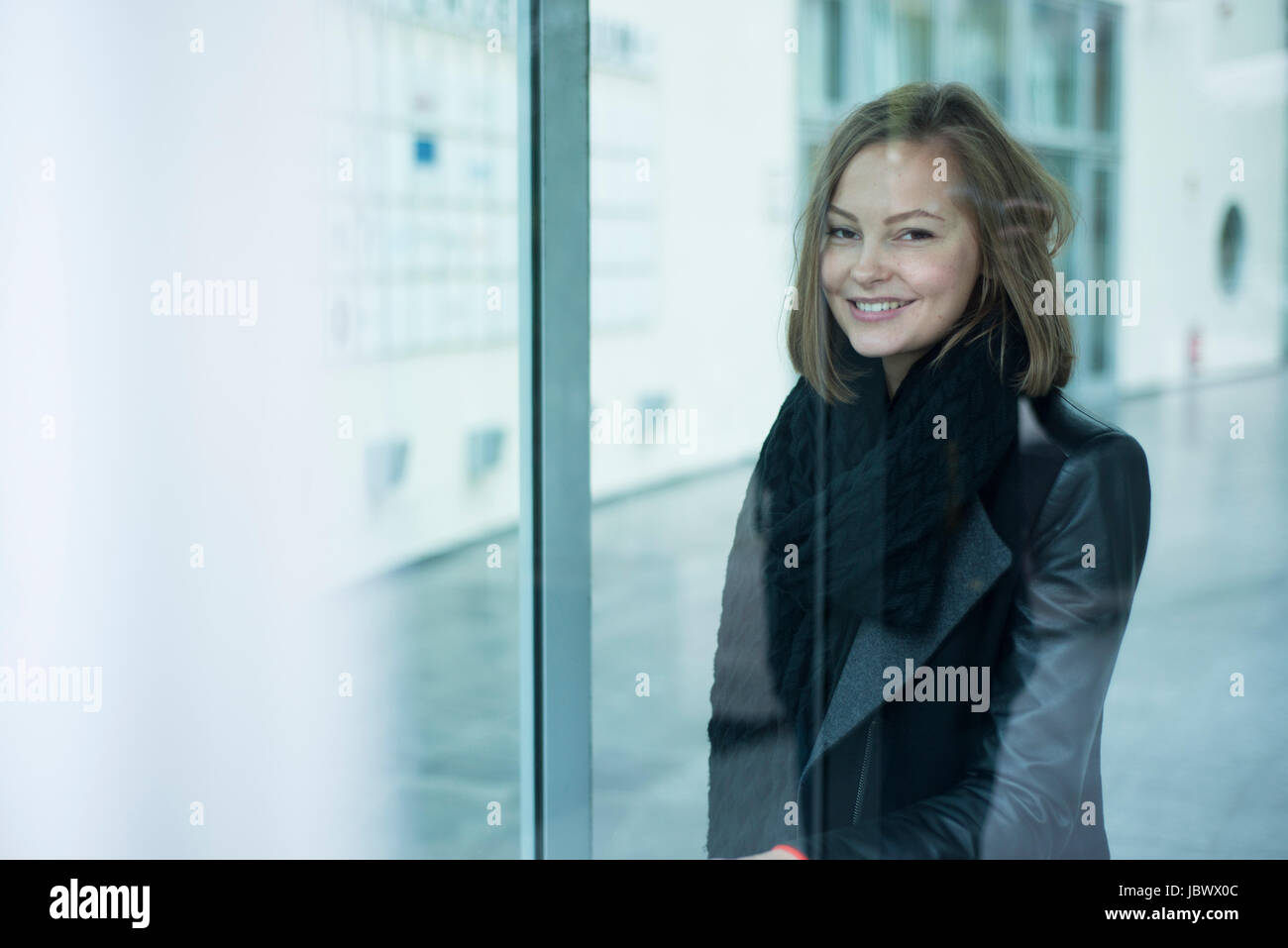 Office window portrait of happy young woman Stock Photo